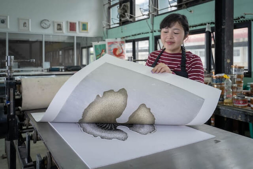 Girl showing Art Printing Techniques in a printshop